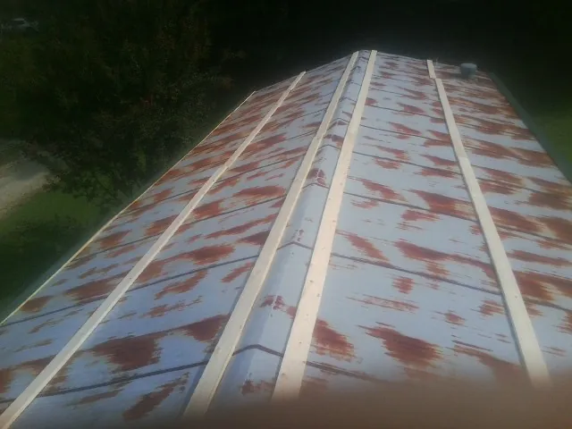 Rusted metal roof panels with new wood purlins before replacement — Storm Damage Roof Repair in Bentonville by Roofing Brothers