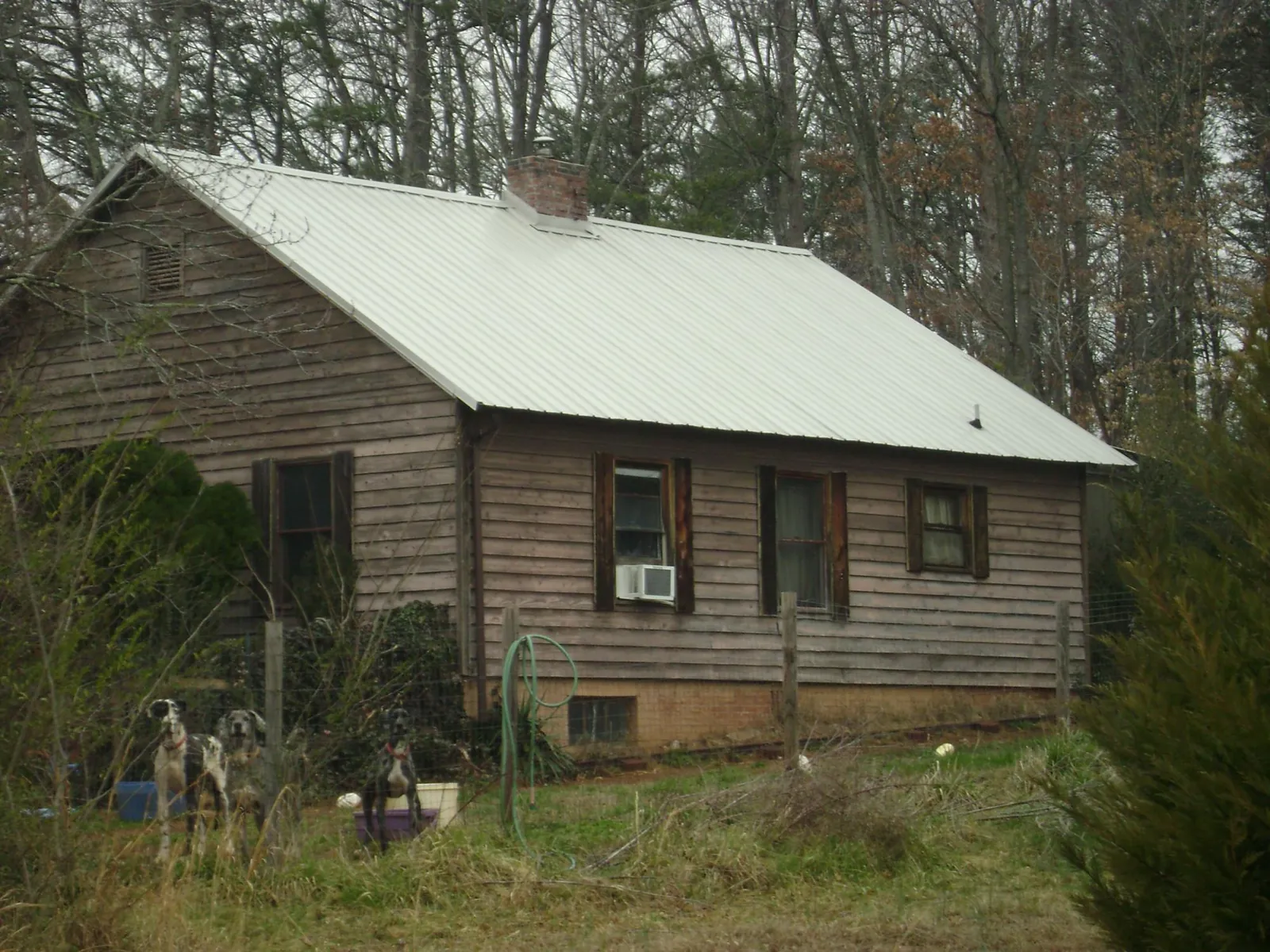 White metal roof on an old wood sided farmhouse, from a Metal Roof Installation job in Bentonville
